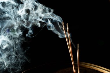 Karanlıkta tütsü dumanıyla dans etmek. Stüdyo çekimi.