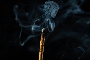 Esmer arka planda tütsü tütsülerinin yakın plan görüntüsü. Stüdyo çekimi.