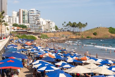 Salvador, Bahia, Brezilya - 05 Ocak 2025: Denizde yıkanan turistlerle dolu Farol da Barra plajının manzarası. Salvador, Bahia.