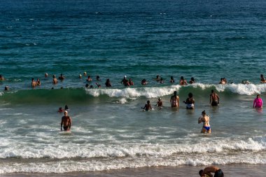 Salvador, Bahia, Brezilya - 05 Ocak 2025: Turistler öğleden sonra Farol da Barra plajında eğlenirken görülüyor. Salvador, Bahia.