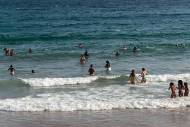 Salvador, Bahia, Brezilya - 05 Ocak 2025: İnsanlar Farol da Barra plajında güçlü öğleden sonra güneşi altında eğlenirken görülüyor. Salvador, Bahia. 