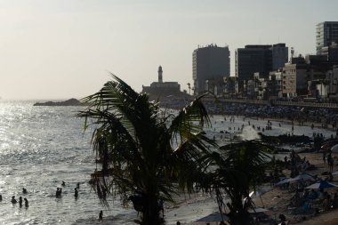 Salvador, Bahia, Brezilya - 05 Ocak 2025: Güneşli bir öğleden sonra, pek çok turistle birlikte Farol da Barra plajının çok uzağından görülmektedir. Salvador, Bahia. 