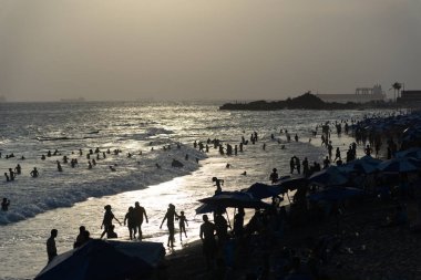 Salvador, Bahia, Brezilya - 05 Ocak 2025: Turistler öğleden sonra Farol da Barra plajında eğlenirken görülüyor. Salvador, Bahia.