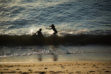 Salvador, Bahia, Brezilya - 24 Ocak 2025: Salvador, Bahia 'da bir plajın kenarında oynayan siluet içinde çocukların görüntüsü.