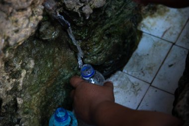 Plastik şişeye su döken kimliği belirsiz birinin eli. Aziz Lucy için ziyafet.