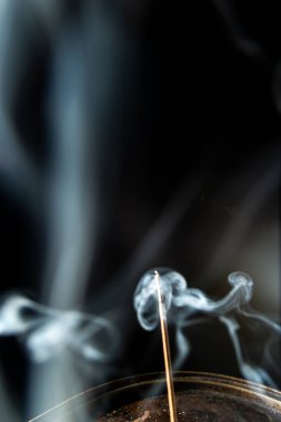 Tütsü çubuğunun ucundan çıkan mavi-beyaz duman. Stüdyo çekimi.