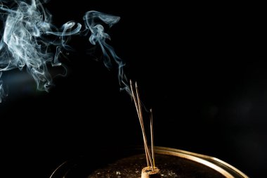 Karanlıkta tütsü dumanıyla dans etmek. Stüdyo çekimi.