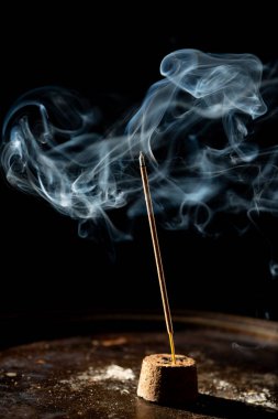 Tütsü çubuğunun ucundan çıkan mavi-beyaz duman. Stüdyo çekimi.