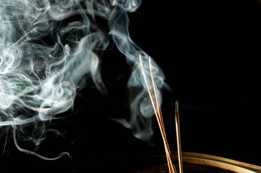 Karanlıkta tütsü dumanıyla dans etmek. Stüdyo çekimi.