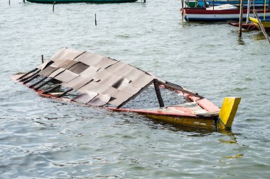 Terk edilmiş ahşap bir teknenin kalıntılarının yarısı bir nehirde batmış. Deniz taşımacılığı