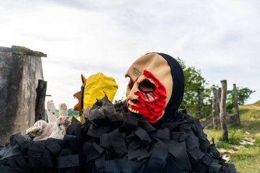 Tanımlanamayan kişi, kırsal bir alanda korku kostümü giymiş, diğer insanlarla oynuyor ve onları korkutuyor. Brezilya 'da karnaval günü.