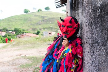Kırsal kesimde korkunç bir kostüm giymiş kimliği belirsiz biri. Brezilya 'da karnaval günü.