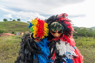 Kırsal kesimde korkunç kostümler giymiş kimliği belirsiz insanlar. Brezilya 'da karnaval günü.