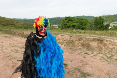 Tanımlanamayan kişi, kırsal bir alanda korku kostümü giymiş, diğer insanlarla oynuyor ve onları korkutuyor. Brezilya 'da karnaval günü.