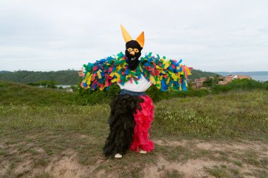 Tanımlanamayan kişi, kırsal bir alanda korku kostümü giymiş, diğer insanlarla oynuyor ve onları korkutuyor. Brezilya 'da karnaval günü.