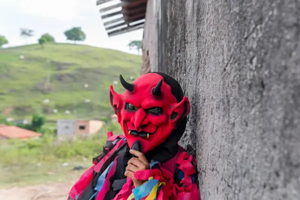 Kırsal kesimde korkunç bir kostüm giymiş kimliği belirsiz biri. Brezilya 'da karnaval günü.