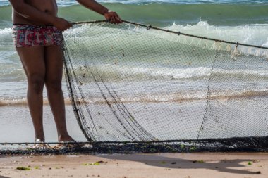 Kimliği belirsiz bir balıkçının balık ağını çektiği yarım ceset. Deniz ürünleri, hobi. Brezilya