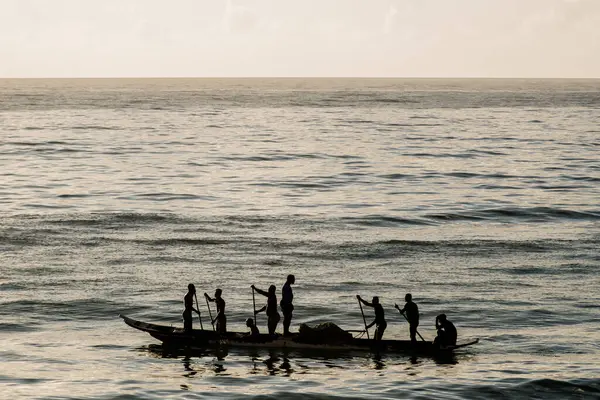 Tanımlanamayan balıkçılar gölgede kanoda balık ağı atıyorlar. Balıkçılık hobisi. Brezilya