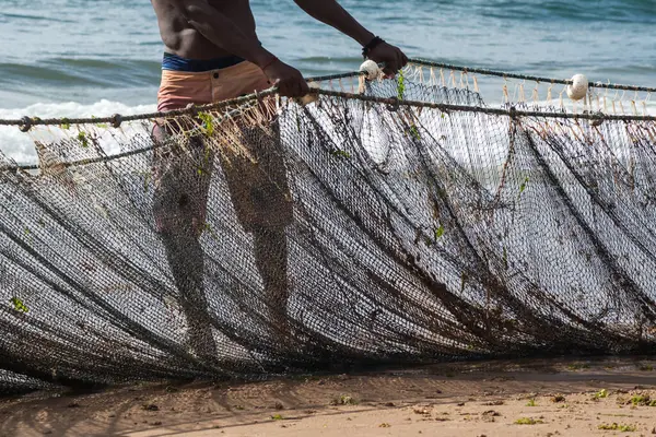 Kimliği belirsiz bir balıkçının balık ağını çektiği yarım ceset. Deniz ürünleri, hobi. Brezilya