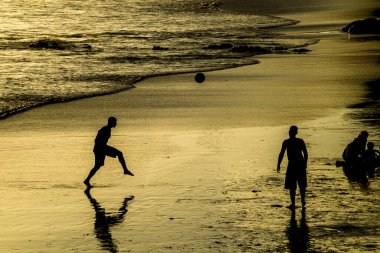 Salvador, Bahia, Brezilya - 22 Aralık 2019: İnsanlar gün batımında plaj futboluyla eğlenirken görülüyor. Salvador, Bahia.