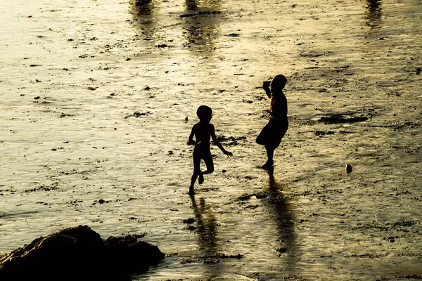 Salvador, Bahia, Brezilya - 22 Aralık 2019: Gençler gün batımında plajda eğlenirken görülüyor. Salvador, Bahia.