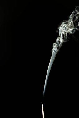Siyah bir arkaplanda tütsüyü dumanla yakmak. Stüdyo çekimi.