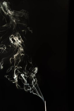 Siyah bir arkaplanda tütsüyü dumanla yakmak. Stüdyo çekimi.