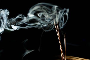 Karanlıkta tütsü dumanıyla dans etmek. Stüdyo çekimi.