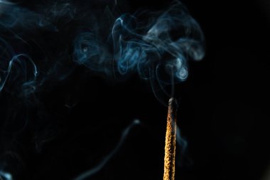 Esmer arka planda tütsü tütsülerinin yakın plan görüntüsü. Stüdyo çekimi.