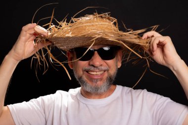 Brezilya 'daki Sao Joao partisi için hasır şapka ve beyaz gömlek giyen gülümseyen sakallı adam. Geleneksel parti.