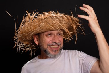 Brezilya 'daki Sao Joao festivalindeki bir karakteri temsil eden beyaz tişörtlü ve hasır şapkalı sakallı bir adam. Geleneksel festival.