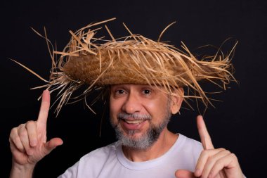 Brezilya 'daki Sao Joao festivalindeki bir karakteri temsil eden beyaz tişörtlü ve hasır şapkalı sakallı bir adam. Geleneksel festival.