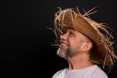 Brezilya 'daki Sao Joao festivalindeki bir karakteri temsil eden beyaz tişörtlü ve hasır şapkalı sakallı bir adam. Geleneksel festival.