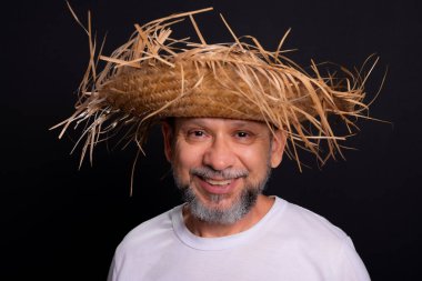 Brezilya 'daki Sao Joao festivalindeki bir karakteri temsil eden beyaz tişörtlü ve hasır şapkalı sakallı bir adam. Geleneksel festival.