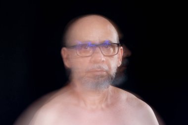 Hareket bulanıklığı efektli güneş gözlüğü takan sakalsız kel adamın sanatsal portresi. Siyah arkaplan.