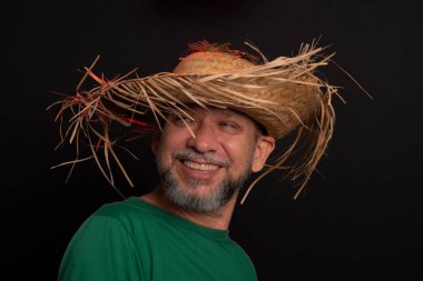 Brezilya 'daki Sao Joao festivali için hasır şapkalı ve yeşil gömlekli gülümseyen sakallı adam. Ülke partisi