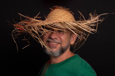 Brezilya 'daki Sao Joao festivali için hasır şapkalı ve yeşil gömlekli gülümseyen sakallı adam. Ülke partisi