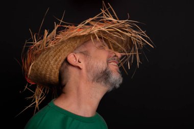 Brezilya 'daki Sao Joao festivali için hasır şapkalı ve yeşil gömlekli gülümseyen sakallı adam. Ülke partisi