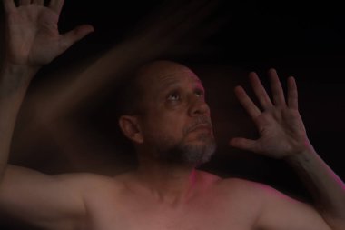 Hareket bulanıklığı efektli güneş gözlüğü takan sakalsız kel adamın sanatsal portresi. Siyah arkaplan.