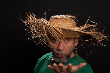 Brezilya 'daki Sao Joao festivali için hasır şapkalı ve yeşil gömlekli gülümseyen sakallı adam. Ülke partisi