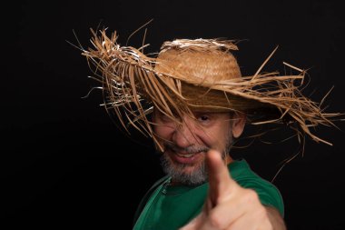 Brezilya 'daki Sao Joao festivali için hasır şapkalı ve yeşil gömlekli gülümseyen sakallı adam. Ülke partisi