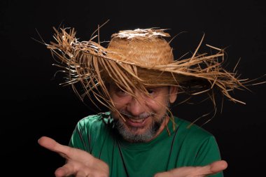 Brezilya 'daki Sao Joao festivali için hasır şapkalı ve yeşil gömlekli gülümseyen sakallı adam. Ülke partisi