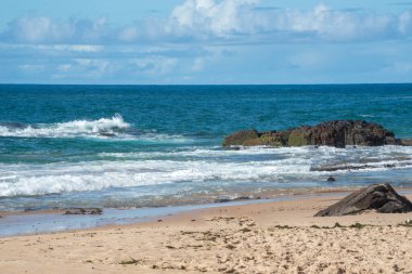 Kumsala vuran dalgaların olduğu sakin bir sahil manzarası. Sıcak yaz günü. Doğa
