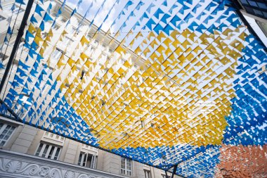 Haziran şenliklerini süsleyen renkli afişler. Plastik nesneler yukarıda asılı. Pelourinho, Brezilya.