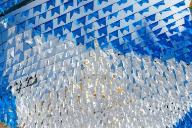 Haziran şenliklerini süsleyen renkli afişler. Plastik nesneler yukarıda asılı. Pelourinho, Brezilya.