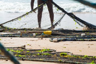 Kimliği belirsiz bir balıkçının balık ağını çektiği yarım ceset. Deniz ürünleri, hobi. Brezilya