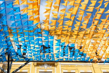 Haziran şenliklerini süsleyen renkli afişler. Plastik nesneler yukarıda asılı. Pelourinho, Brezilya.