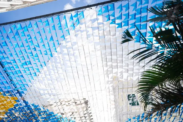 Haziran şenliklerini süsleyen renkli afişler. Plastik nesneler yukarıda asılı. Pelourinho, Brezilya.