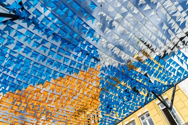 Haziran şenliklerini süsleyen renkli afişler. Plastik nesneler yukarıda asılı. Pelourinho, Brezilya.