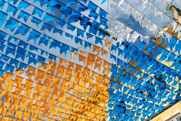 Haziran festivalinin renkli bayraklarla süslenmesi. Üstte plastik nesneler var. Pelourinho, Brezilya.